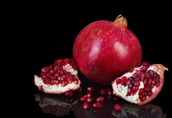 Ripe pomegranate fruit isolated on a black background