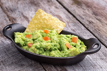 Chunky homemade guacamole in cast iron dish