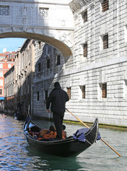 Fototapeta na wymiar Gondolier on channel of the bridge of sighs in Venice