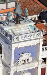 venice clock tower with blackened statues and winged lion