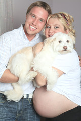Belly of a Very Pregnant Woman with is boyfriend and with a dog