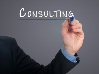 Businessman hand writing Consulting. Grey background.