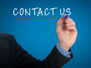 Businessman hand writing contact us. Blue background