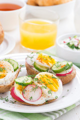 buns with egg and vegetables on plate for breakfast, vertical