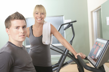 Young athletic couple in gym on training