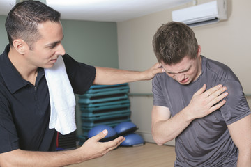 Portrait of a fitness man reaching for his knee in pain