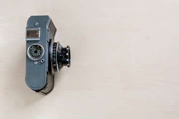 Vintage photo camera on a wooden board