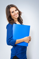 Naklejka premium Cheerful young business woman with blue folder