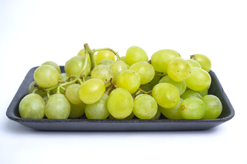 Green grape in black styrofoam with isolated white background