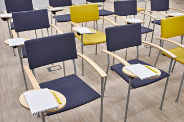 Chairs with notepads in empty classroom