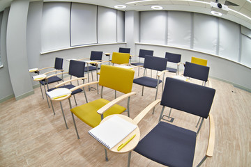 Chairs with notepads in empty classroom