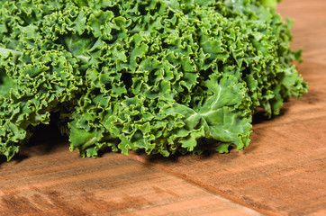 Curly kale leaves on wooden table