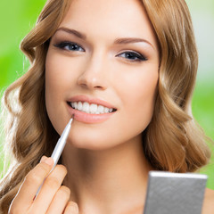 Woman with make up brush, outdoors