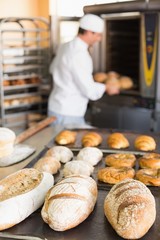 Happy baker taking out fresh loaves