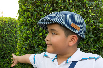 Asian boy playing hide and seek with his mother in the garden.