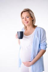 forty years old pregnant woman isolated and drinking with mug