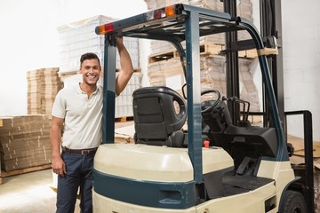 Manual worker leaning against the forklift