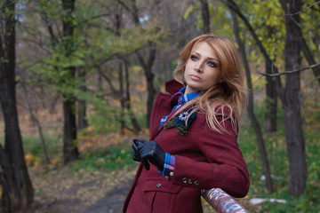 Fototapeta na wymiar Beautiful blonde woman in jacket and leather gloves in autumn fo