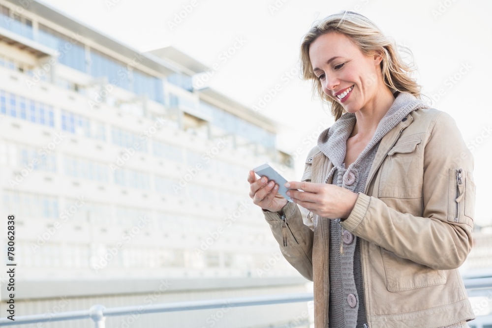Poster smiling blonde standing and text messaging