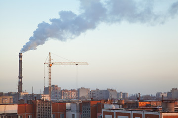 Boiler pipe smoke above roofs of high-rise apartment buildings