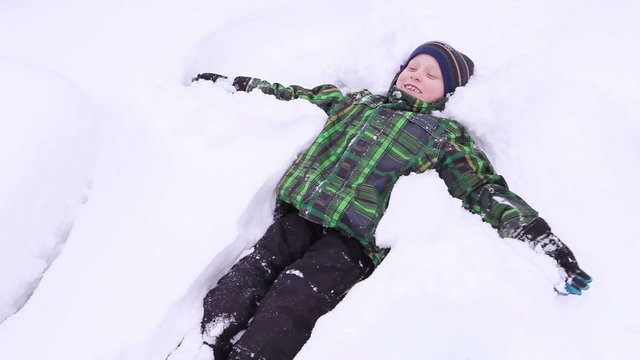 Little boy smiling and doing Snow angel