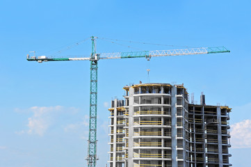 Naklejka premium Crane and building construction site against blue sky