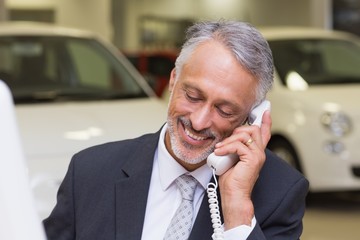Smiling businessman making a phone call