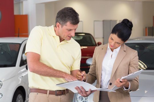 Salesperson talking with her customer while holding a booket