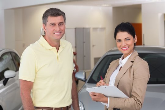 Smiling businessman undersign a car contract