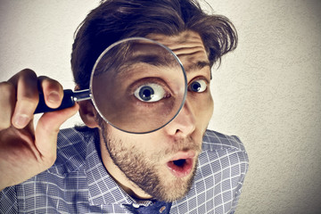 Businessman looks through a magnifying lens