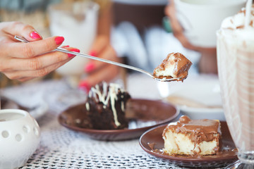 Female hand holding a piece of cake on a spoon