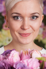 Fototapeta premium blond woman holding flowers, looking up, short haircut