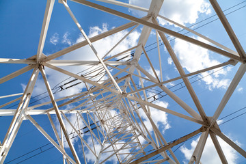Obraz premium Bottom view power transmission lines against blue sky
