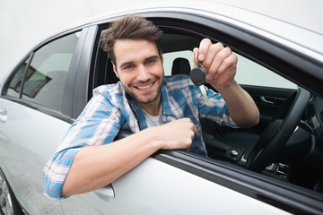Naklejka premium Young man smiling and holding key