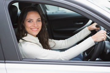 Fototapeta na wymiar Pretty woman smiling and driving