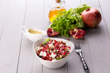 Healthy salad with pomegranate seeds, almond, feta cheese and
