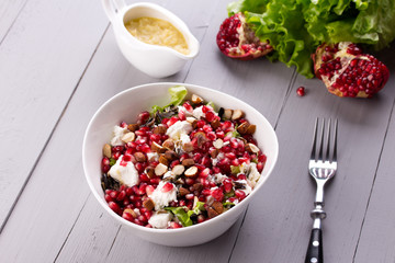 Healthy salad with pomegranate seeds, almond, feta cheese and