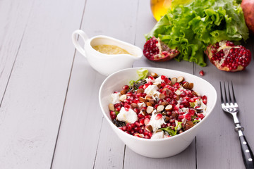 Healthy salad with pomegranate seeds, almond, feta cheese and
