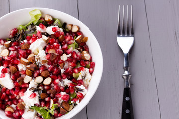 Healthy salad with pomegranate seeds, almond, feta cheese and