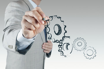 businessman hand draws gear to success concept