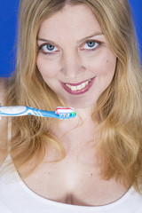 Model Released. Happy Young Woman Brushing Teeth