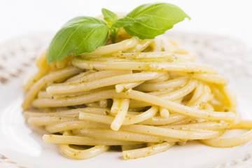 Italian pasta spaghetti with pesto sauce and basil leaf