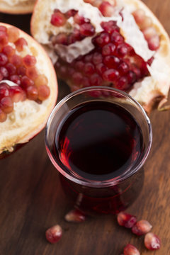 Ripe pomegranates with juice on table