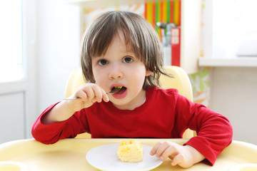2 years boy eating scrambled eggs. Healthy nutrition © ivolodina
