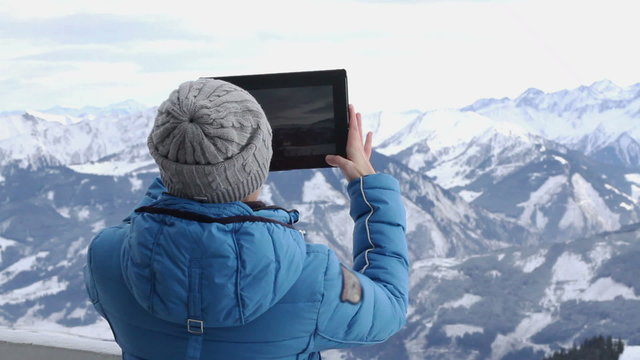 Woman hiker taking photo with digital tablet, Alps