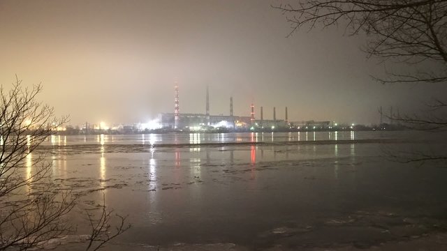 Farthest panorama of electricity plant in fog by a river while