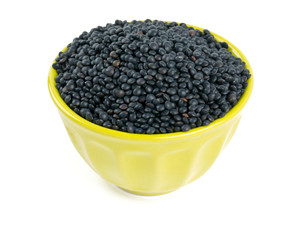 black lentils in a bowl isolated on white