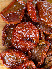 sun dried tomatoes with olive oil on wooden surface