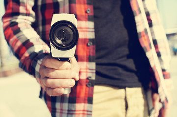 young man pointing a Super 8 camera at the observer