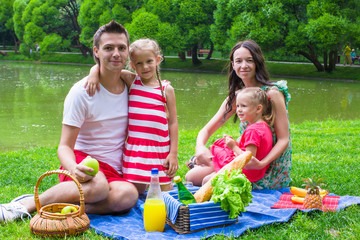 Happy young family picnicking outdoors